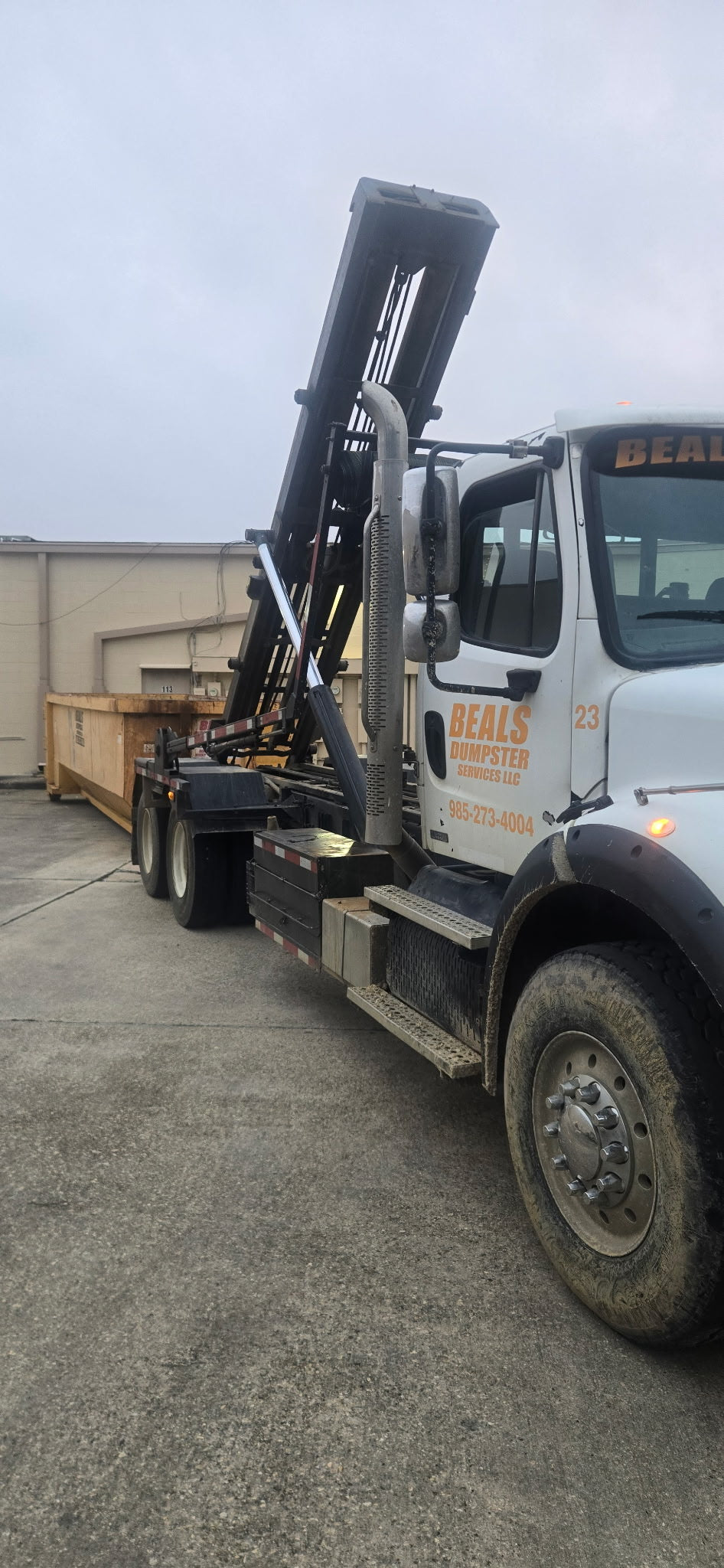 Beals roll-off dumpster truck hauling a container