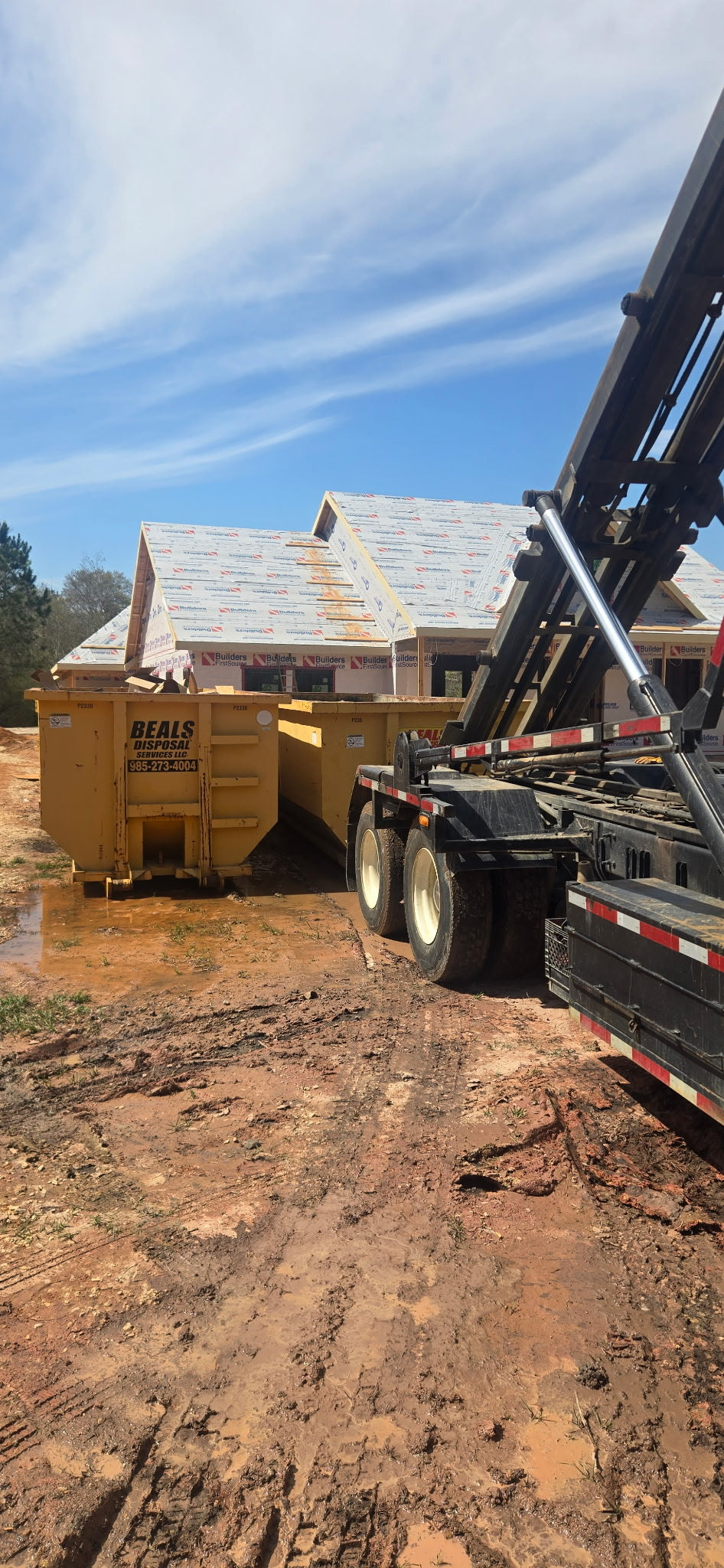 Beals truck delivering a roll-off dumpster at a new home construction site